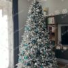 Umelý vianočný stromček 3D Jedľa Alabastrová 240cm ozdobený modrými a striebornými ozdobami.